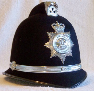 South Wales Constabulary Helmet, 1984 - 1996
South Wales Constabulary Helmet, approx 1984 - 1996, coxcomb design with large chrome centre band and side rosettes. Motto 'Ich Dien' on the Prince of Wales Feathers is german for 'I Serve'
Keywords: south wales helmet Headwear