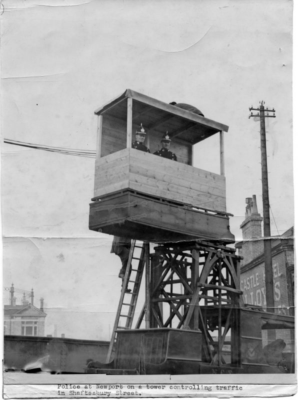 NEWPORT BOROUGH POLICE, TRAFFIC CONTROL
I think the left PC could be #32 but it is rather blurry.
Photo credit the Western mail and Echo Ltd., and is titled "Police at Newport on a tower controlling traffic in Shaftsbury Street".
The vehicle has the Newport coat-of-arms on the side.
